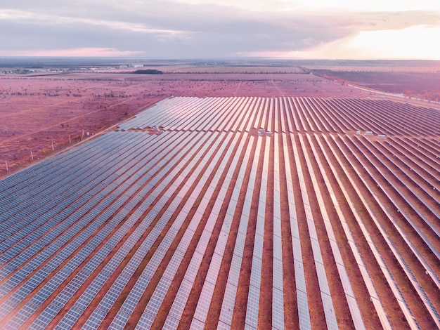 Vista aérea de uma usina de painéis solares, painéis solares fotovoltaicos ao nascer e pôr do sol em