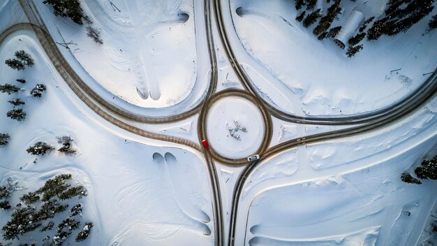 Foto vista aérea do cruzamento de estradas rurais no inverno conceito de viagens rodoviárias e de transporte na floresta de neve