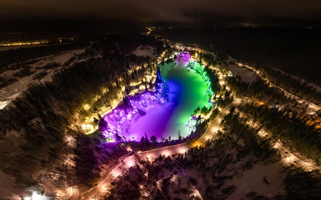 Vista aérea do desfiladeiro de mármore em uma noite de inverno Belas iluminações coloridas iluminação festiva Parque de pedreiras Ruskeala Karelia Rússia Finlândia Escandinávia do Norte Russa