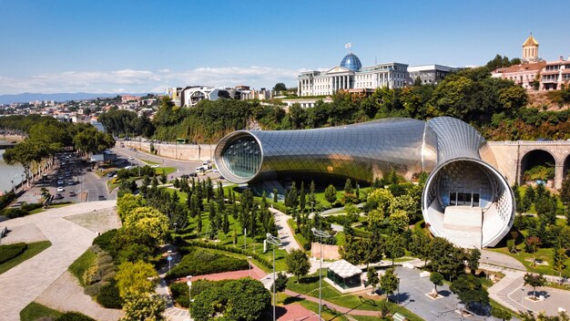 Vista aérea do drone de Tbilisi, Geórgia. Rike Park com vegetação e edifícios modernos, rio Kura