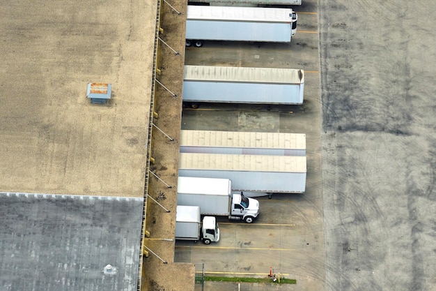 Vista aérea do grande centro de distribuição comercial com muitos caminhões descarregando e carregando produtos de varejo para posterior remessa Conceito de economia global