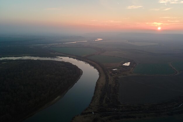 Vista aérea do largo rio fluindo calmamente na zona rural na noite de outono.