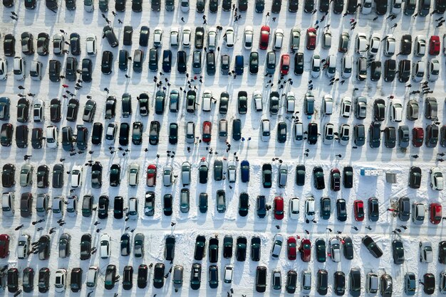 Vista aérea do lote de mercado aberto de veículos com muitos carros para venda estacionados e clientes de pessoas andando no inverno