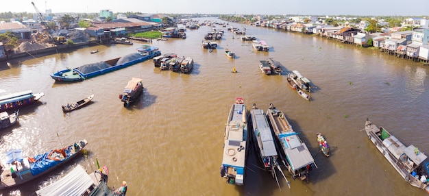 Vista aérea do mercado flutuante de Cai Rang ao nascer do sol, barcos que vendem frutas e produtos por atacado no rio Can Tho, região do Delta do Mekong, Vietnã