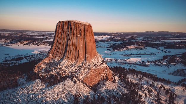 Foto vista aérea do monumento nacional devil's tower contra o céu durante o pôr do sol no inverno