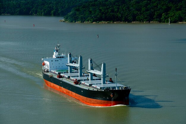 Vista aérea do navio de carga de grãos em trânsito cruzando o lago Gatun no Canal do Panamá foto de stock