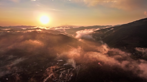 Vista aérea do pôr do sol sobre a paisagem de montanhas.