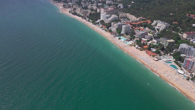 Vista aérea do resort de Golden Sands, na Bulgária, durante a temporada de verão. Uma série de hotéis, piscinas e multidões de pessoas desfrutando do mar.