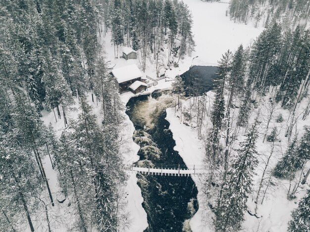 Vista aérea do rio Icy que flui através de uma bela paisagem de inverno nevado no Parque Nacional de Oulanka Ruka Finlândia Drone fotografia