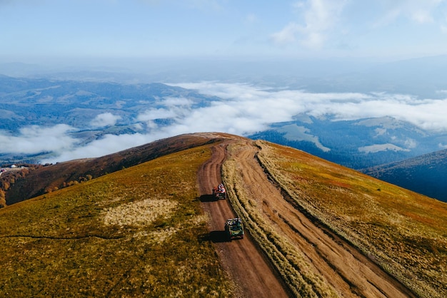 Vista aérea do suv off road travel subindo pela colina da montanha