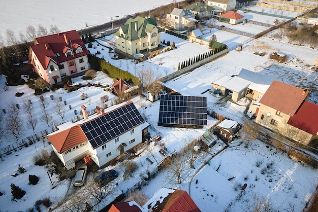 Vista aérea do telhado da casa com painéis solares cobertos de neve derretendo no final do inverno para produzir energia limpa Conceito de baixa eficácia de eletricidade renovável na região norte