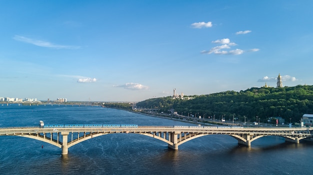 Vista aérea do zangão da ponte ferroviária metro com trem e o rio dnieper