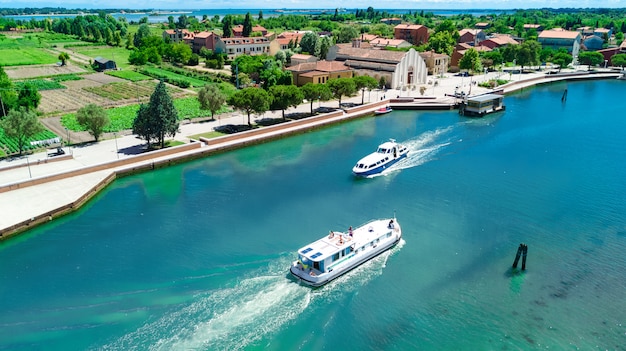 Vista aérea do zangão de casa flutuante na lagoa veneziana, cruzeiro de viagens em família de barco de férias na itália