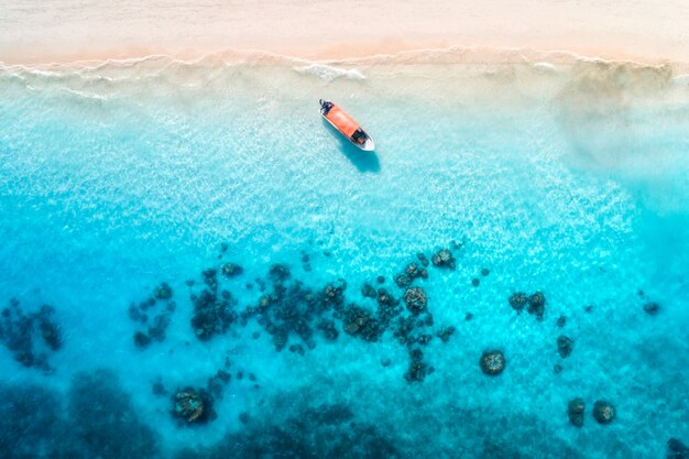 Vista aérea dos barcos de pesca na água azul clara ao pôr do sol