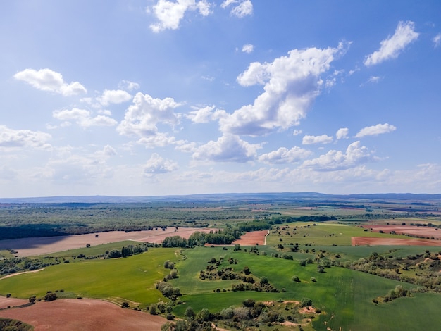 Vista aérea dos campos de castela com parcelas agrícolas e céu azul com nuvens