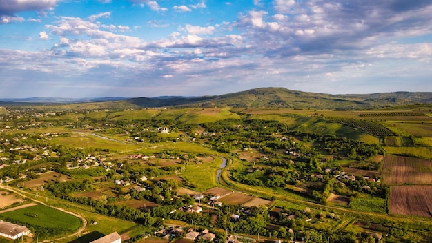 Vista aérea de drone de una aldea en Moldavia al atardecer Edificios residenciales iglesia río estrecho