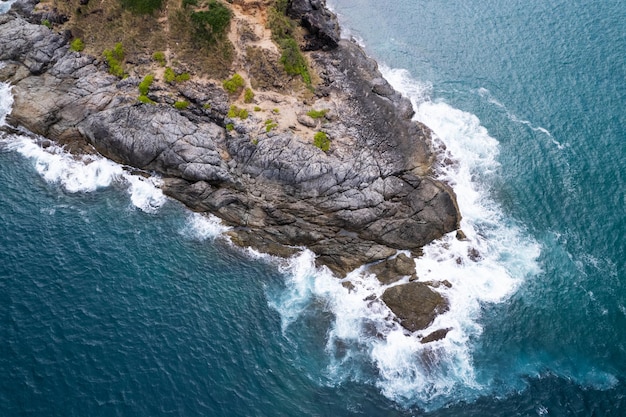 Vista aérea drone câmera de cima para baixo de rochas à beira-mar em um oceano azul superfície do mar turquesa ondas incríveis do mar batendo na paisagem de rochas imagem de alta qualidade das ondas do mar em phuket tailândia