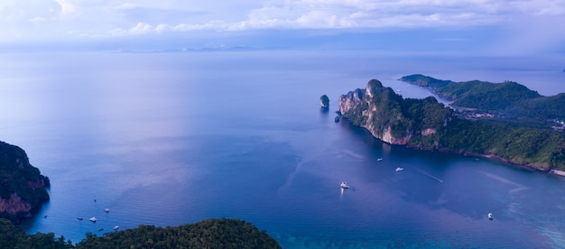 Vista aérea de drone de la isla tropical de Ko Phi Phi y pasajeros de barcos en el agua de mar azul claro de Andaman desde arriba, hermosa temporada alta Krabi, Tailandia