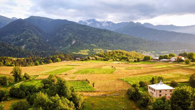 Vista aérea de drone de la naturaleza en Georgia al atardecer Valley Village con campos, montañas y colinas