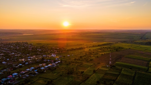 Vista aérea de drone de un pueblo de Moldavia al atardecer. Amplios campos a su alrededor