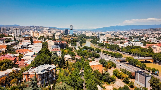 Vista aérea de drone de Tbilisi, Georgia, varios edificios, una gran cantidad de vegetación del río Kura