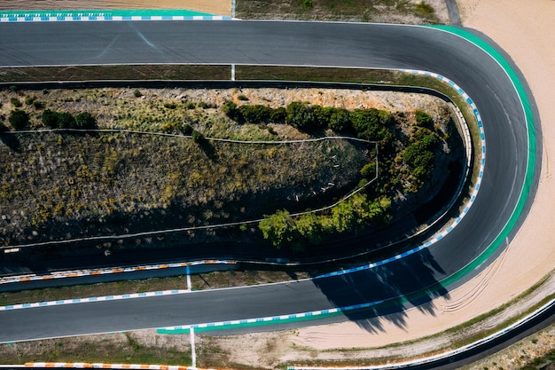 Vista aérea de drones de arriba hacia abajo de una pista de carreras con curvas cerradas y horquillas