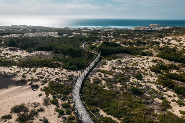 Vista aérea de drones del camino peatonal a la playa de Guincho en Cascais Portugal junto a las dunas de arena Cabo da Roca visible en el extremo derecho