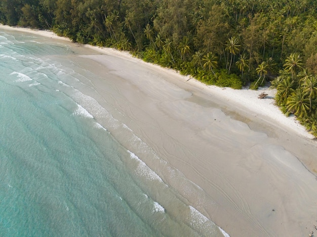 Vista aérea de drones de una hermosa playa con agua de mar turquesa y palmeras del golfo de Tailandia, isla de Kood, Tailandia