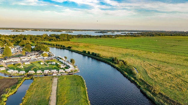 Vista aérea de drones del típico paisaje holandés con canales, agua de pólder, campos verdes y casas de campo desde arriba, Holanda, Países Bajos