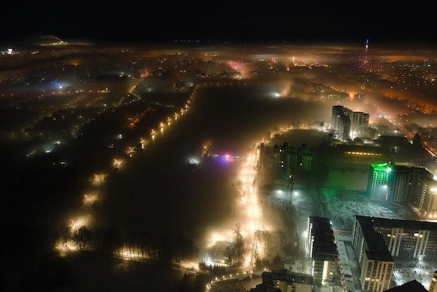 Vista aérea de edificios de apartamentos de gran altura y calles iluminadas en la zona residencial de la ciudad de IvanoFrankivsk Ucrania por la noche Paisaje urbano oscuro
