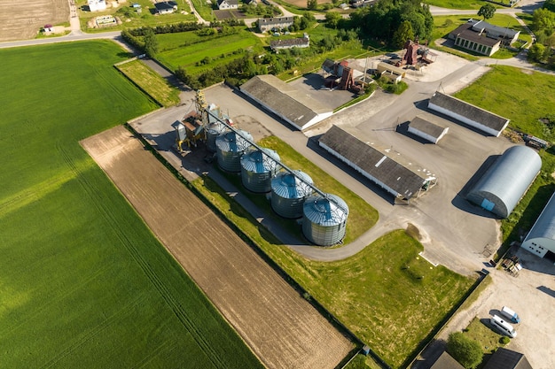 Foto vista aérea del elevador de granero de agrosilos en la planta de fabricación de agroprocesamiento para procesar, secar, limpiar y almacenar productos agrícolas, harina, cereales y granos