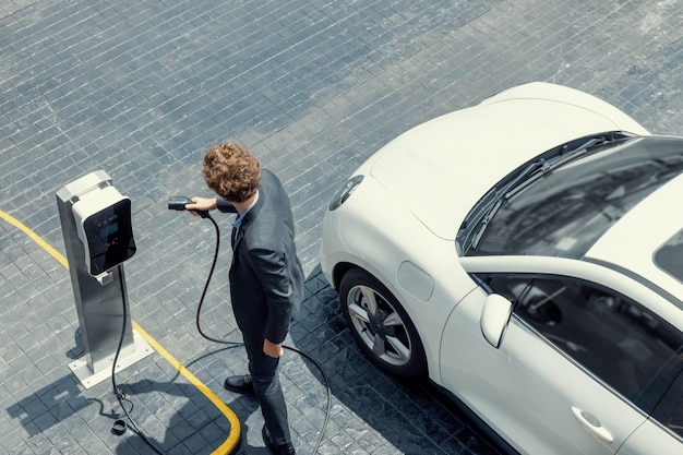 Vista aérea del empresario progresista con batería de recarga de coche EV