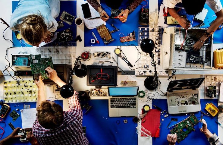 Foto vista aérea del equipo de técnicos en electrónica trabajando.