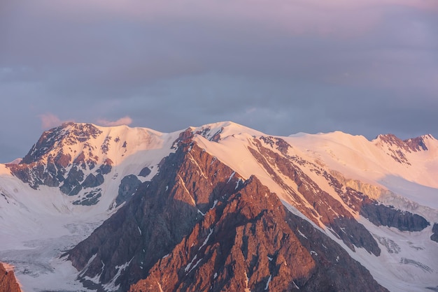 Vista aérea escénica de altas montañas nevadas temprano en la mañana al amanecer Impresionante paisaje con montañas doradas iluminadas por el sol en el cielo nublado al amanecer Paisaje matutino con cordillera nevada a la luz del sol dorada