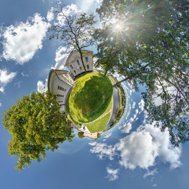 Vista aérea esférica del pequeño planeta en el bosque cerca de la casa de vacaciones en un buen día con nubes agradables