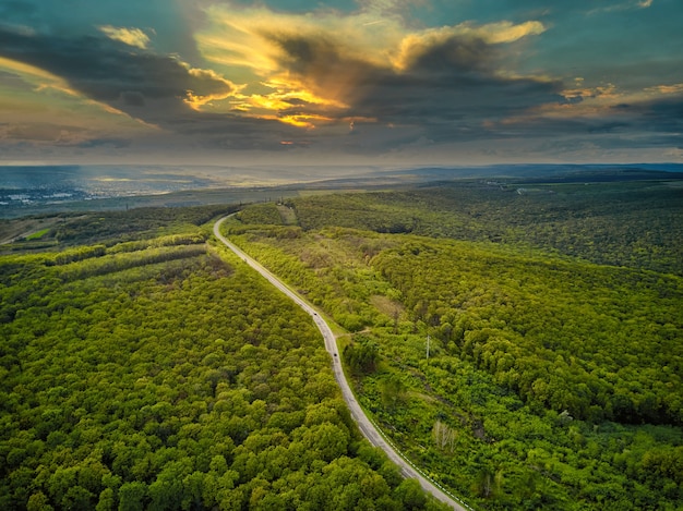 Vista aérea del espeso bosque en otoño con la carretera que atraviesa