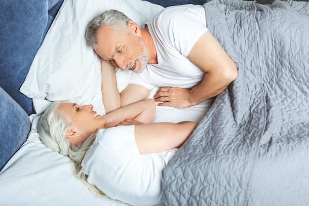 Vista aérea de la esposa y el esposo acostados en la cama antes de dormir