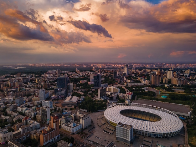 Vista aérea del estadio de fútbol de la ciudad con el telón de fondo de la puesta de sol y hermosas nubes