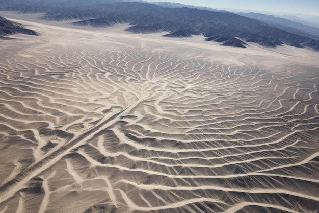 Una vista aérea expansiva captura un paisaje desértico con altas montañas en el fondo lejano las icónicas líneas de Nazca vistas desde la perspectiva de las aves.