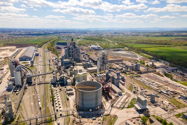 Vista aérea de la fábrica de cemento con alta estructura de hormigón y grúa torre en el área de producción industrial. Concepto de industria global y fabricación.