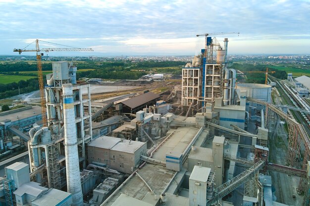 Vista aérea de la fábrica de cemento con estructura de planta de hormigón alta y grúa torre en el sitio de producción industrial. Concepto de industria global y fabricación.