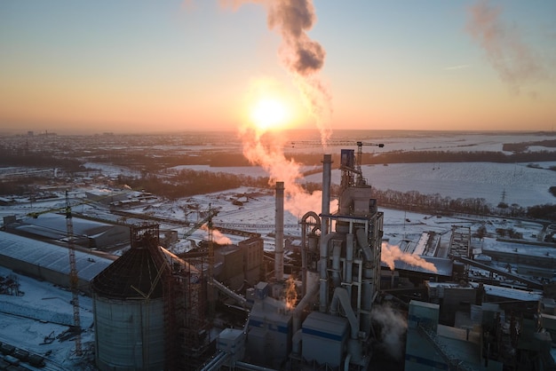 Vista aérea de la fábrica de cemento con estructura de planta de hormigón alto y grúa torre en el área de producción industrial por la noche Fabricación y concepto de industria global