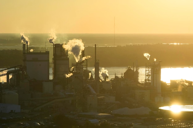 Vista aérea de la fábrica de procesamiento de madera con humo del proceso de producción que contamina la atmósfera en el patio de fabricación de la planta Sitio industrial al atardecer