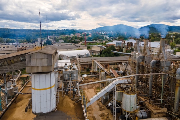 Vista aérea de la fábrica de procesamiento de madera con humo del proceso de producción que contamina la atmósfera en el patio de fabricación de la planta