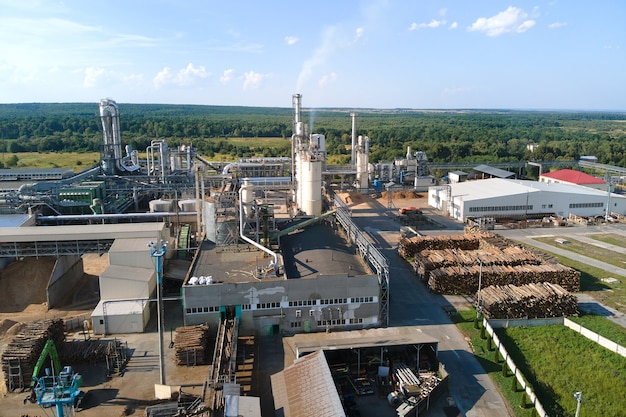 Vista aérea de la fábrica de procesamiento de madera con pilas de madera en el patio de fabricación de la planta.