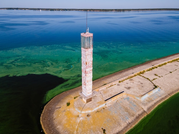 Vista aérea del faro rodeado de floración de algas