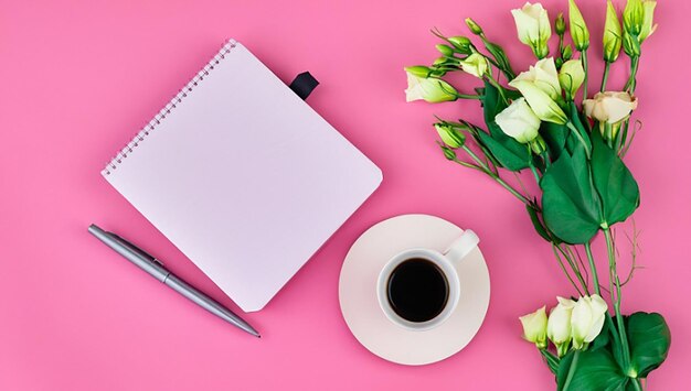 Una vista aérea de las flores de eustoma con pluma de tarjeta de diario y taza de café en el espacio de copia de fondo rosa