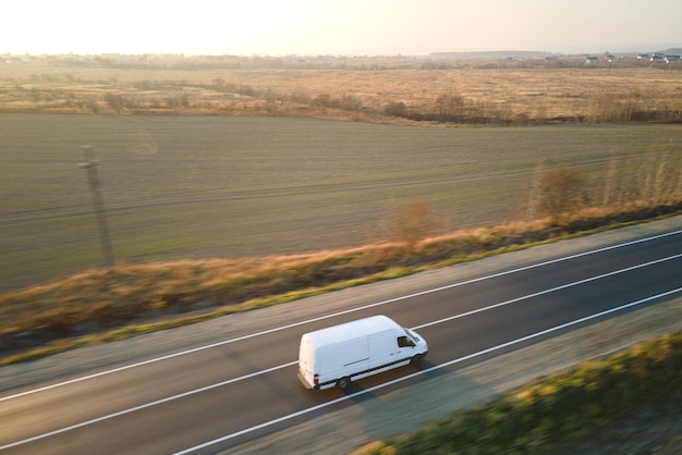 Vista aérea de la furgoneta de carga de movimiento rápido borrosa conduciendo por la carretera transportando mercancías. Concepto de logística y transporte de entrega