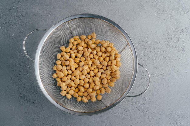 Vista aérea de garbanzos en tamiz sobre fondo gris Legumbres para veganos Plato orgánico Concepto de alimentación saludable Vegetarianismo