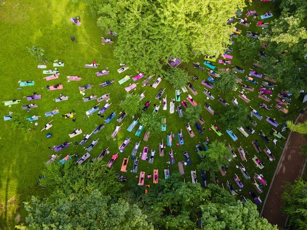 Vista aérea de la gente que hace yoga en el parque público de la ciudad